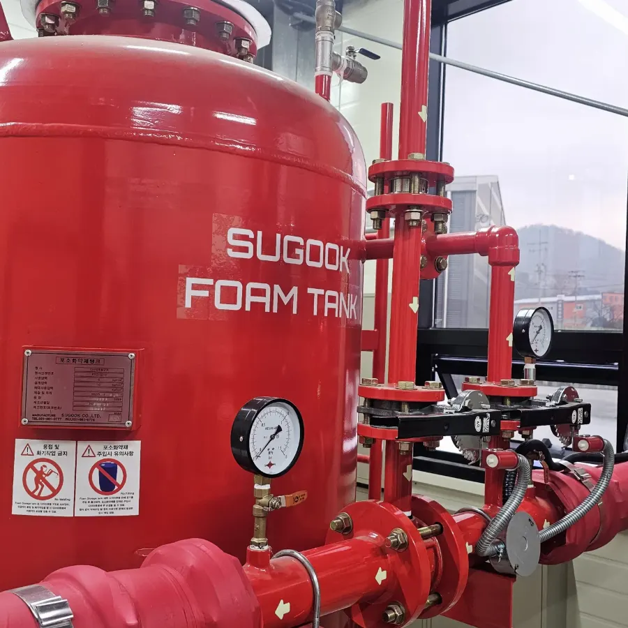 폼탱크 몸체에 SUGOOK FOAM TANK 표기가 있고 배관에 압력계가 설치된 기계실 설비